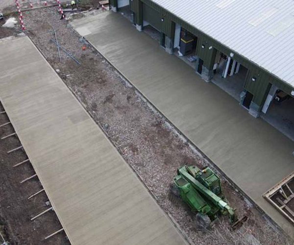 Commercial concrete slab being poured outside an industrial building